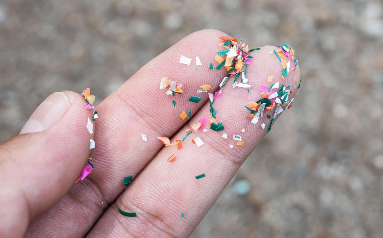 Nahaufnahme von Mikroplastik auf Fingern