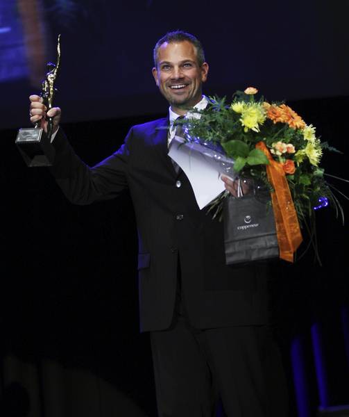 Grosser Preis des Mittelstands Markus Baumann mit Pokal und Blumenstrauß