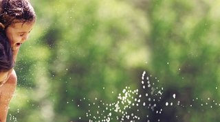 Glückliche Familie spielt mit Wasser