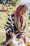 Mädchen wäscht Geschirr mit sauberem Wasser in Nepal